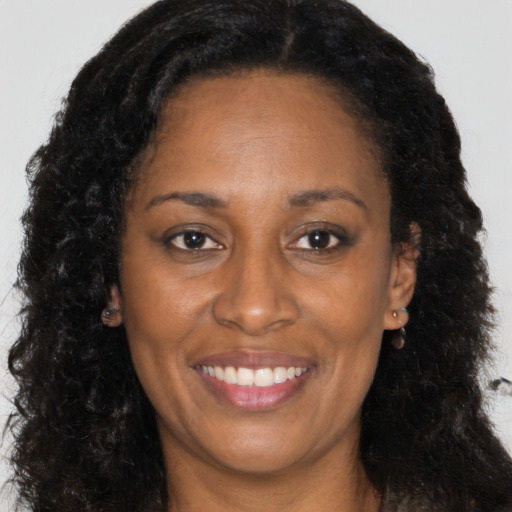 Joyful black adult female with long  brown hair and brown eyes