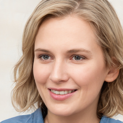 Joyful white young-adult female with medium  brown hair and blue eyes