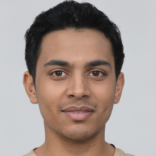 Joyful latino young-adult male with short  black hair and brown eyes