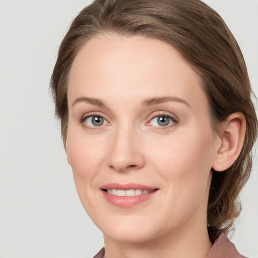 Joyful white young-adult female with medium  brown hair and grey eyes