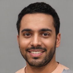 Joyful latino young-adult male with short  black hair and brown eyes