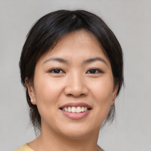 Joyful asian young-adult female with medium  brown hair and brown eyes