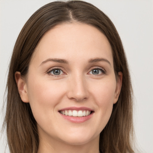 Joyful white young-adult female with long  brown hair and grey eyes