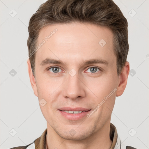 Joyful white young-adult male with short  brown hair and grey eyes