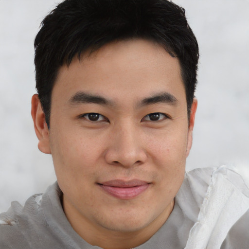 Joyful asian young-adult male with short  brown hair and brown eyes