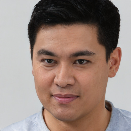 Joyful latino young-adult male with short  brown hair and brown eyes