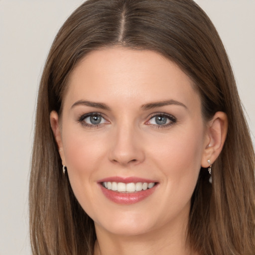 Joyful white young-adult female with long  brown hair and grey eyes