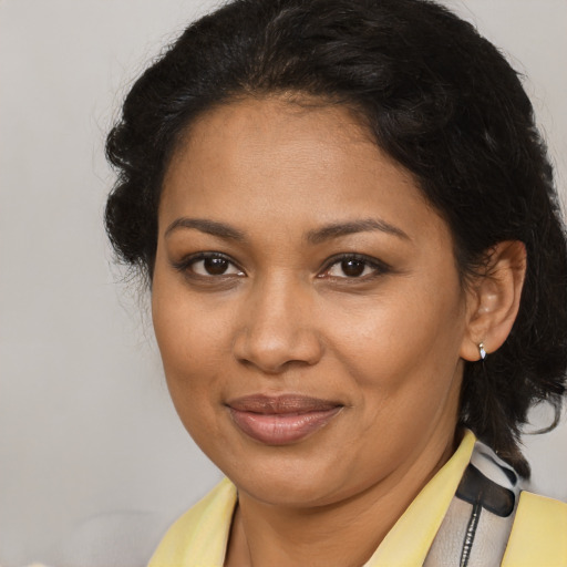 Joyful black adult female with medium  brown hair and brown eyes