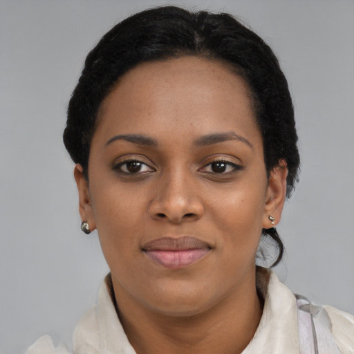 Joyful black young-adult female with short  black hair and brown eyes