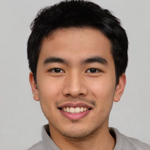 Joyful asian young-adult male with short  black hair and brown eyes