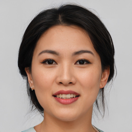 Joyful asian young-adult female with medium  black hair and brown eyes