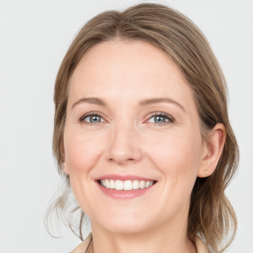 Joyful white adult female with medium  brown hair and blue eyes