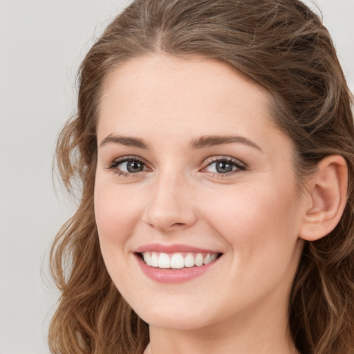 Joyful white young-adult female with long  brown hair and green eyes