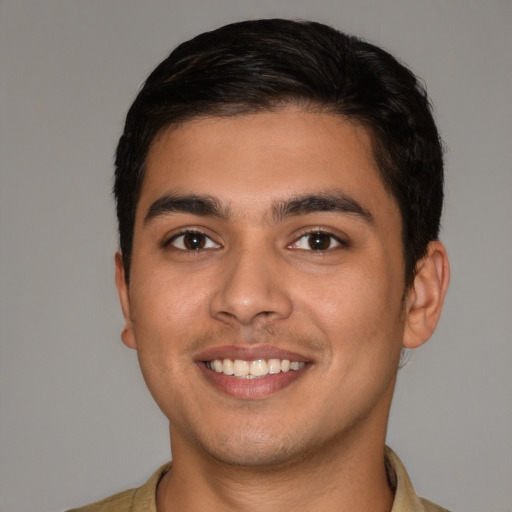 Joyful latino young-adult male with short  brown hair and brown eyes