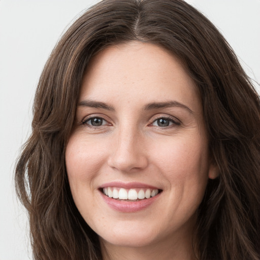 Joyful white young-adult female with long  brown hair and grey eyes