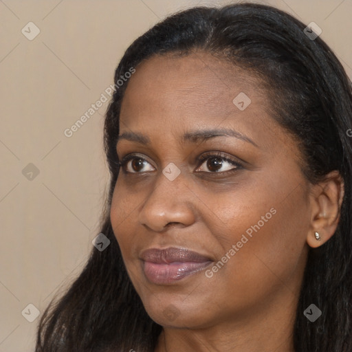 Joyful black adult female with long  brown hair and brown eyes