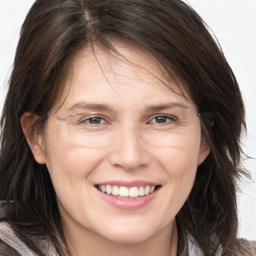 Joyful white adult female with long  brown hair and brown eyes