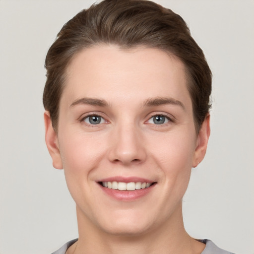 Joyful white young-adult female with short  brown hair and grey eyes