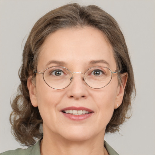 Joyful white adult female with medium  brown hair and green eyes