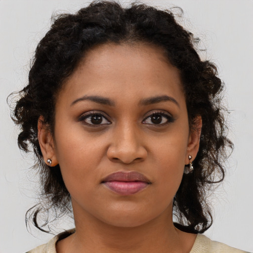 Joyful black young-adult female with long  brown hair and brown eyes