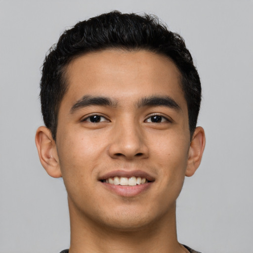 Joyful latino young-adult male with short  black hair and brown eyes