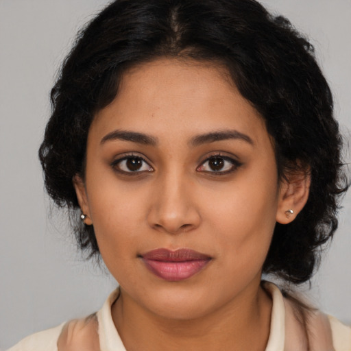 Joyful latino young-adult female with medium  brown hair and brown eyes