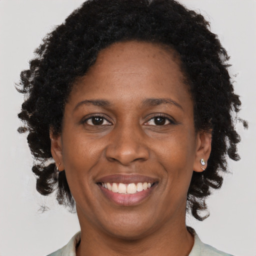 Joyful black adult female with short  brown hair and brown eyes