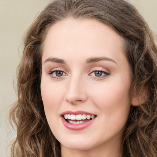 Joyful white young-adult female with long  brown hair and green eyes