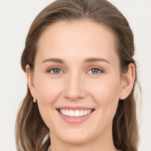 Joyful white young-adult female with long  brown hair and grey eyes