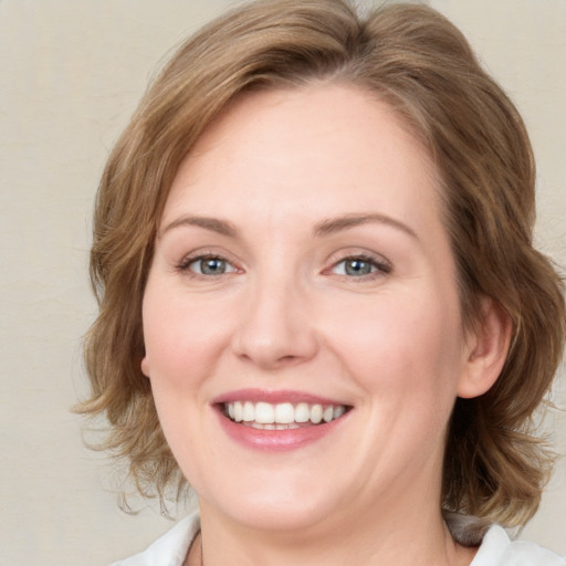 Joyful white young-adult female with medium  brown hair and blue eyes