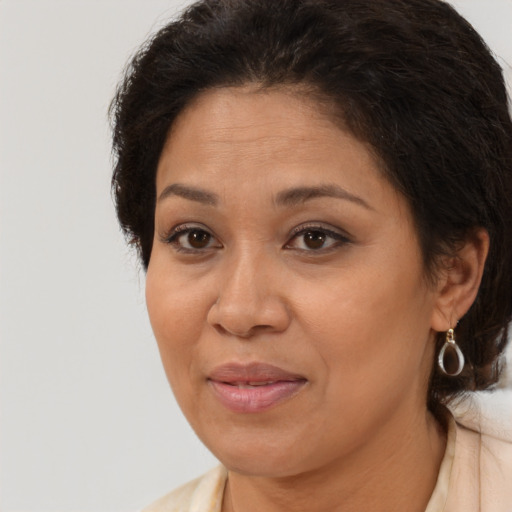 Joyful latino adult female with medium  brown hair and brown eyes