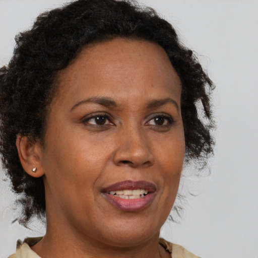 Joyful black adult female with medium  brown hair and brown eyes