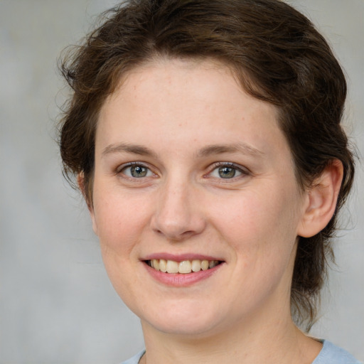 Joyful white young-adult female with medium  brown hair and green eyes