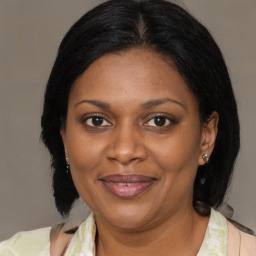 Joyful black adult female with medium  brown hair and brown eyes