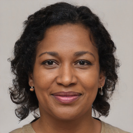 Joyful black adult female with medium  brown hair and brown eyes