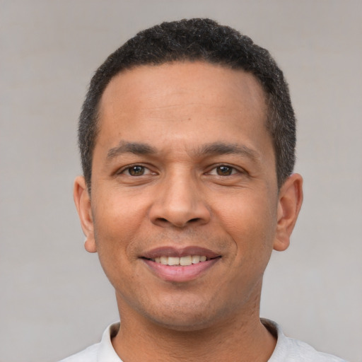 Joyful latino young-adult male with short  black hair and brown eyes