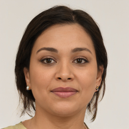 Joyful latino young-adult female with medium  brown hair and brown eyes