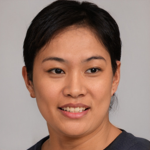 Joyful asian young-adult female with short  black hair and brown eyes