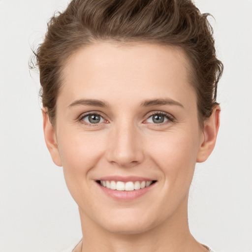 Joyful white young-adult female with short  brown hair and grey eyes