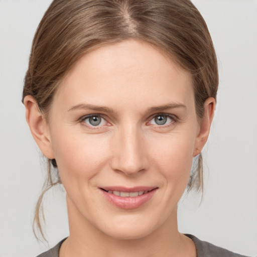 Joyful white young-adult female with medium  brown hair and grey eyes