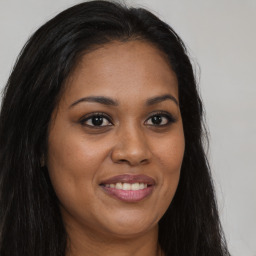 Joyful black young-adult female with long  brown hair and brown eyes