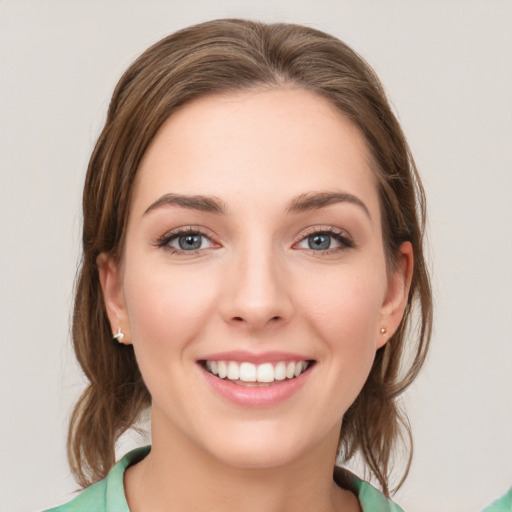 Joyful white young-adult female with medium  brown hair and green eyes