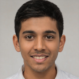 Joyful latino young-adult male with short  black hair and brown eyes