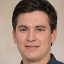 Joyful white adult male with short  brown hair and grey eyes