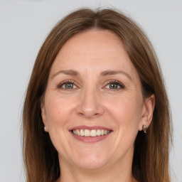 Joyful white adult female with long  brown hair and grey eyes