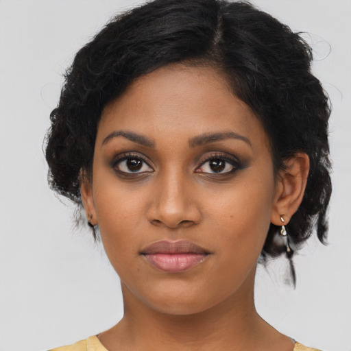 Joyful black young-adult female with medium  brown hair and brown eyes