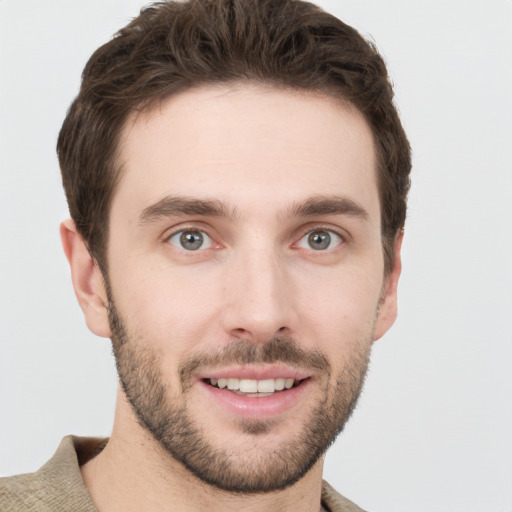 Joyful white young-adult male with short  brown hair and grey eyes