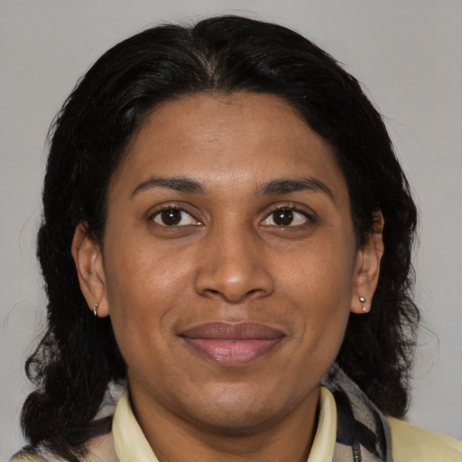 Joyful latino adult female with medium  brown hair and brown eyes