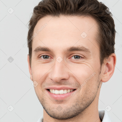 Joyful white young-adult male with short  brown hair and brown eyes