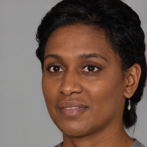 Joyful black young-adult female with medium  black hair and brown eyes